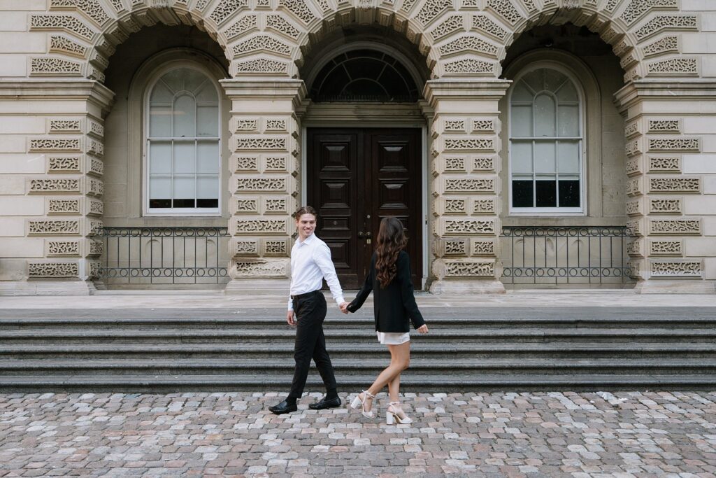 Couple walking past each other outside Osgoode Hall in Downtown Toronto