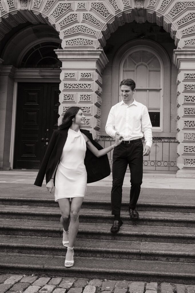 Man walking lady down a set of stairs outside Osgoode Hall in Toronto